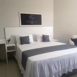 a bedroom with a large bed and a desk at Loft no Refúgio do Sahy in Mangaratiba +14 photos