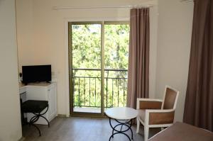 a living room with a large window and a table and chairs at Mira Beach Resort Bodrum - All inclusive in Bodrum City