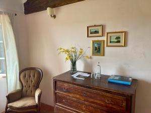 a desk with a chair and a vase of flowers on it at Borgo Belsedere - biofarm estate resort in Tuscany in Trequanda
