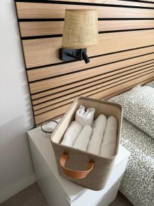 a basket of towels sitting on a drawer next to a bed at Appartement central - ORLEANS in Orléans +2 photos