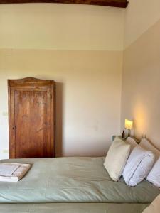 a bedroom with a bed with a wooden door at Borgo Belsedere - biofarm estate resort in Tuscany in Trequanda