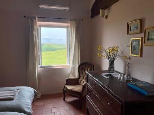a bedroom with a dresser and a desk with a window at Borgo Belsedere - biofarm estate resort in Tuscany in Trequanda +75 photos