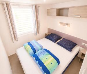 two beds in a small room with a window at Greenchalets Roquebrune Sur Argens in Roquebrune-sur-Argens +37 photos