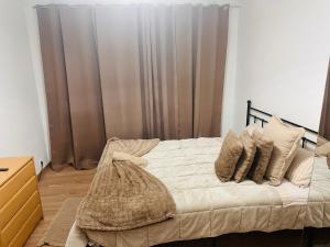 a bedroom with a bed with pillows and curtains at Casa Paz in Alcabideche +3 photos