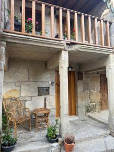 a patio with a table and chairs and a balcony at Vida Entre Balcones in Combarro