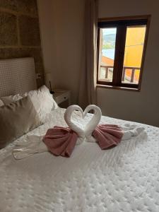 two swans making a heart on a bed at Vida Entre Balcones in Combarro
