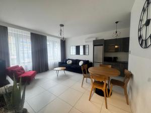 a kitchen and living room with a table and a couch at Apartament Noniewicza 95 in Suwałki