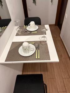 a table with two plates and glasses on it at Casa Paz in Alcabideche