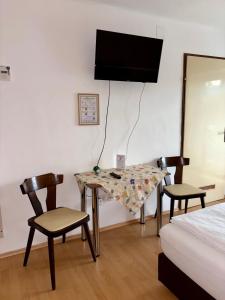 a room with a table and two chairs and a bed at Pension Schwartzwirt in Neusiedl am Steinfelde