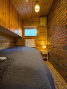 ein großer Raum mit einer Ziegelwand und einem Fenster in der Unterkunft Whispering Woods Cabin in Porvoo