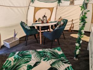 a room with a table and chairs in a tent at The Shire Glamping in Kearsney