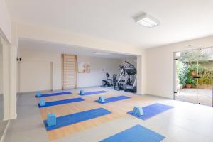 a yoga room with a bunch of blue mats at Hotel Estia in Finikounta +21 photos