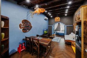 a dining room with a table and a room with a couch at Little Sun Homestay - Free Buggy Tour check-in Sunset Town in Phú Quốc