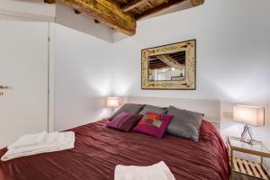 una camera da letto con un grande letto con cuscini viola di Pellegrino Campo de' Fiori Suite a Roma
