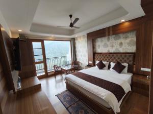 a bedroom with a large bed and a balcony at Hotel Summer Hill in Chail