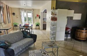 a living room with a couch and a table at Maison piscine chauffée in Puybegon