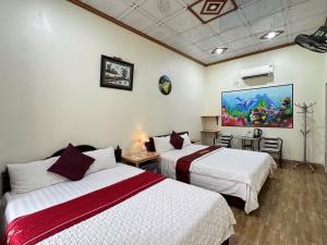 a hotel room with two beds and a painting on the wall at Tam Coc Thanh Dat Homestay in Ninh Binh +98 photos