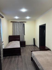 a bedroom with two beds and a window at Happy Holidays in Yerevan