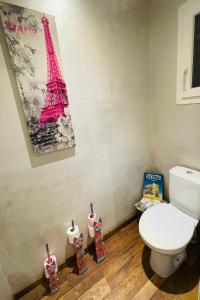 a bathroom with a toilet and a picture of the eiffel tower at Studio Cosy in Saint-Juéry +2 photos