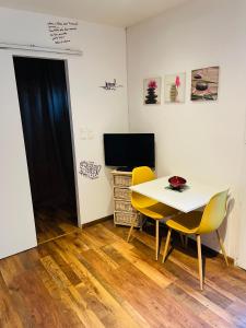 a room with a table and two chairs and a television at Studio Cosy in Saint-Juéry