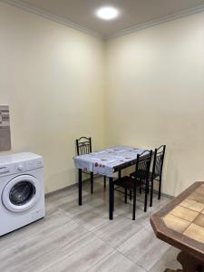 a dining room with a table and a washing machine at Happy Holidays in Yerevan