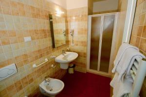 a bathroom with a sink and a toilet and a shower at charmante apartament lake front in Malcesine +16 photos