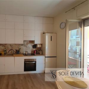 a kitchen with white cabinets and a refrigerator at Sole di Vita in Marina di Strongoli +23 photos