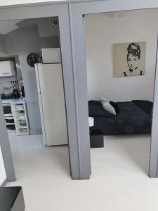 a small bedroom with a bed and a refrigerator at Charmant T3 au Cœur de Grenoble in Grenoble