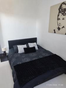 a bedroom with a bed with a black and white blanket at Charmant T3 au Cœur de Grenoble in Grenoble