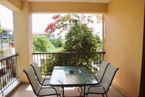 a balcony with a table and chairs and a tree at Mellonia in Nikiti