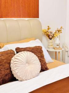 a white pillow on a bed with brown pillows at Terracotta Azure in San Fernando