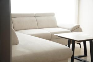 a living room with a white couch and a table at Apartman Premium Posušje in Posušje