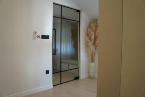 a glass door in a room with a vase at Apartman Premium Posušje in Posušje