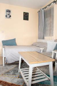 a bedroom with a bed and a coffee table at Saagite Apartments in Ongata Rongai 