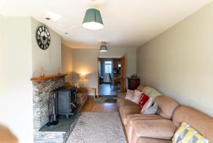 a living room with a couch and a fireplace at Riverview House - Cahersiveen in Cahersiveen