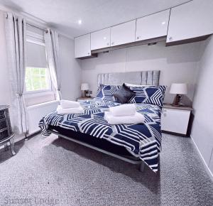 a bedroom with a large bed with blue and white sheets at Sunset lodge 32 in West Thirston +13 photos