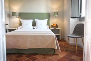 a hotel room with a bed and a chair at Hotel Casa Calella in Calella de Palafrugell