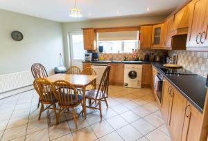 a kitchen with a table and chairs in it at Riverview House - Cahersiveen in Cahersiveen +7 photos