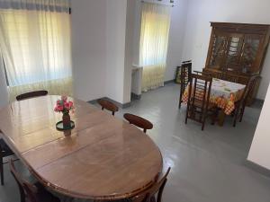 a dining room with a wooden table and chairs at Melani Villa in Kandy