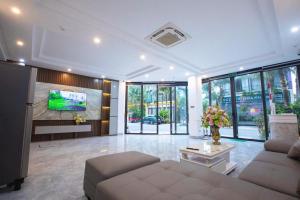 a living room with a couch and a tv at Villa Flamingo C607 in Thanh Hóa