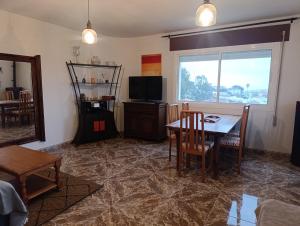 a living room with a table and a television at La Casuca in El Pelayo