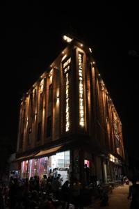 a group of people sitting outside of a building at night at Hotel SR Siddhivinayak Mathura in Mathura