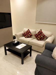 a living room with a couch and a coffee table at الفرسان للشقق المخدومه in Al Kharj
