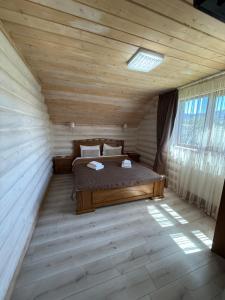 a bedroom with a bed in a wooden room at Beauty House in Mykulychyn +19 photos