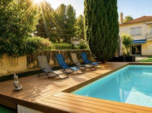 a deck with chairs and a swimming pool at Isa's Sweet Homes in Saint-Mitre-les-Remparts