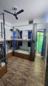 a room with two bunk beds and a ceiling fan at The Travelers Nest Home Stay in Jhānsi