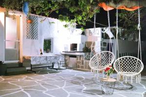 a patio with chairs and a table and a swing at The Nest in Astris