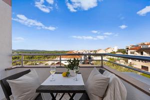 a balcony with a table and two glasses of wine at Villa Baron - Adriatic Sea View in Šibenik