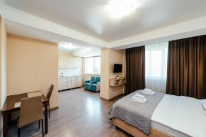 a hotel room with a bed and a desk and a table at Apart Hotel Anastasia in Chişinău