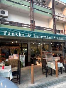 a restaurant with tables and chairs in front of a building at Homer House Hostel & Café in Vientiane